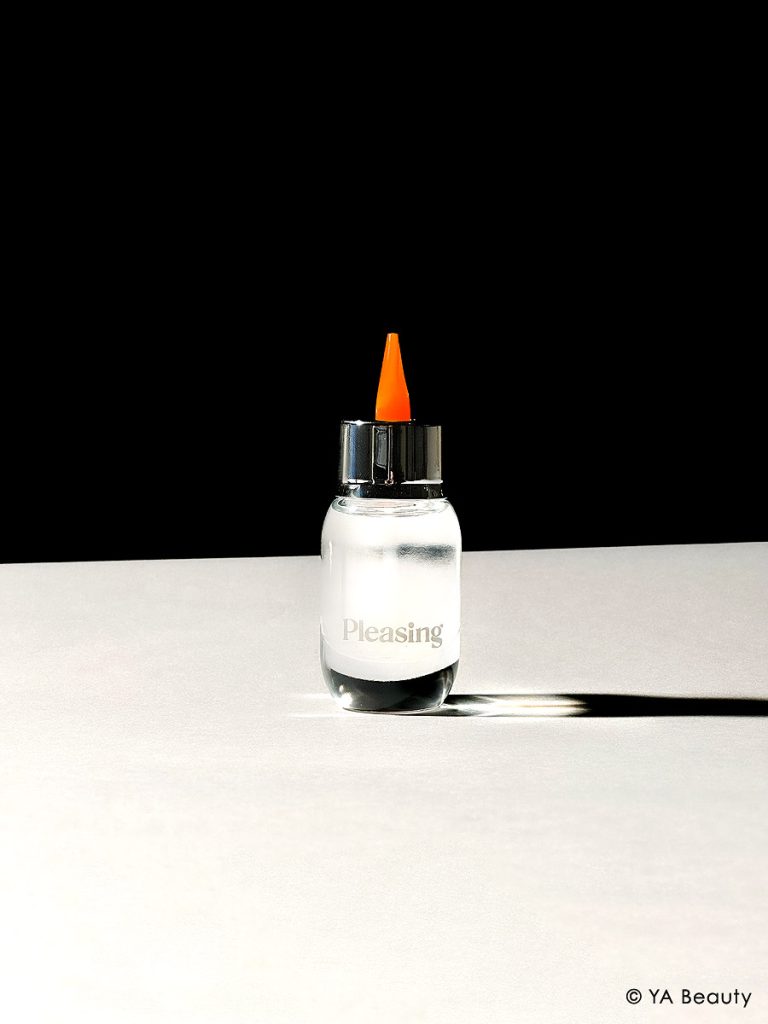 The Pleasing by Harry Styles x Marco Ribeiro collaboration product Gloss Medium. The clear glass bottle is strikingly photographed on black and white background