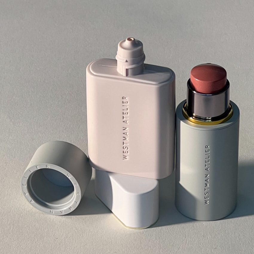 Striking photograph of Westman Atelier Vital Skincare Complexion Drops and Baby Cheeks Blush Stick in shade Petal stacked together, set against a clean, gray background.